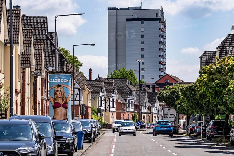 Residential buildings, on Nobelstrasse, in the Wiesdorf district, in Leverkusen, Bayer AG's Werkssiedlung II, heritage-protected building, residential tower block in the background, advertising pillar Caledonia Werbung, Leverkusen, North Rhine-Westphalia, Germany