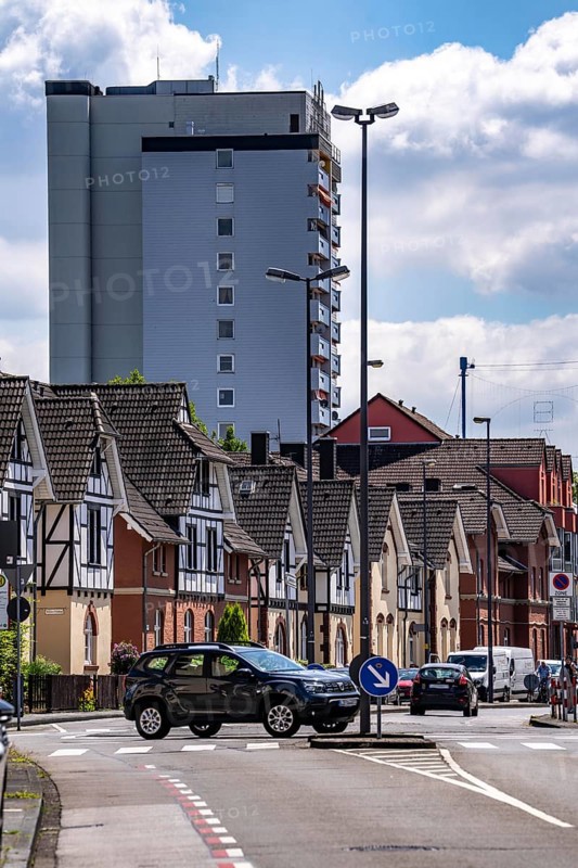 Residential buildings, on Nobelstrasse, in the Wiesdorf district, in Leverkusen, Bayer AG's Plant Estate II, heritage-protected building, in the background residential tower block and Bayer Cross in Chempark Leverkusen, North Rhine-Westphalia, Germany