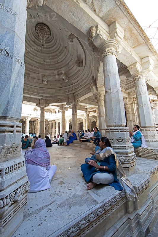Indian woman praying between the white marble pillars in the Adinath temple in Ranakpur, Jain temple, Rajasthan, India