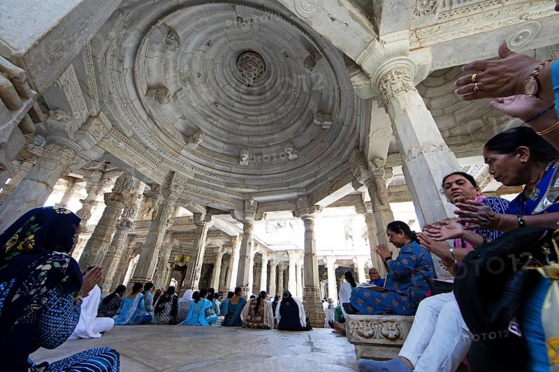 Indian woman praying between the white marble pillars in the Adinath temple in Ranakpur, Jain temple, Rajasthan, India