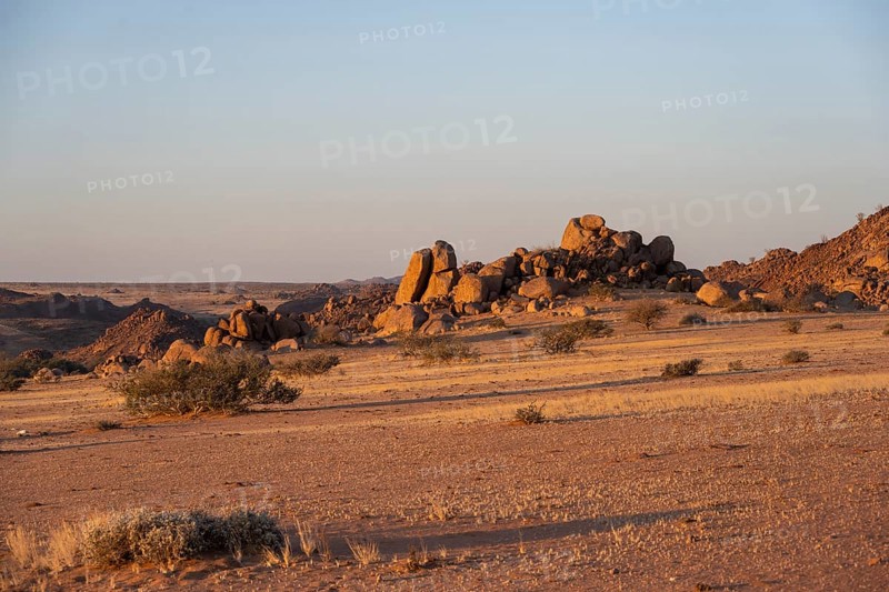 Barren landscape with hills of stacked rocks, desert landscape in the evening light at sunset, Erongo, Damaraland, Namibia