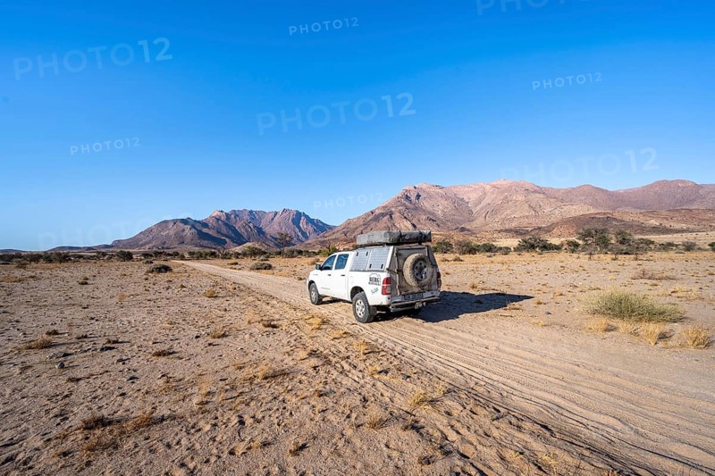 Off-road vehicle on a sandy track, desert landscape with Brandberg, Erongo, Damaraland, Namibia