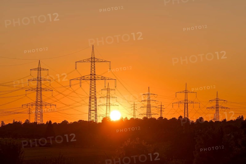 Electricity pylons in front of a glowing sunset on the horizon, Waiblingen, Baden-Württemberg, Germany
