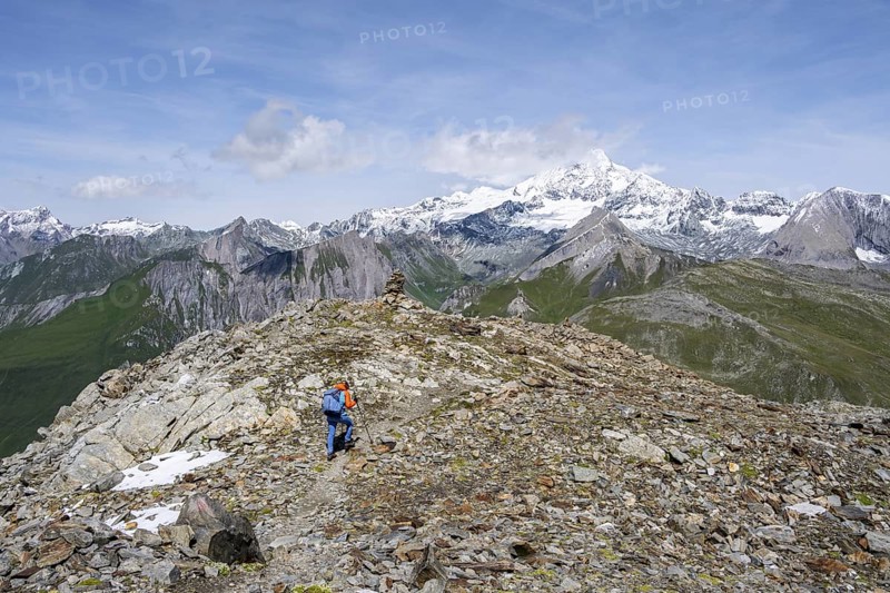 Mountaineer on a hiking trail, snow-covered and glaciated summit of the Großglockner in the background, Wiener Höhenweg, Schober Group, Hohe Tauern National Park, Carinthia, Austria