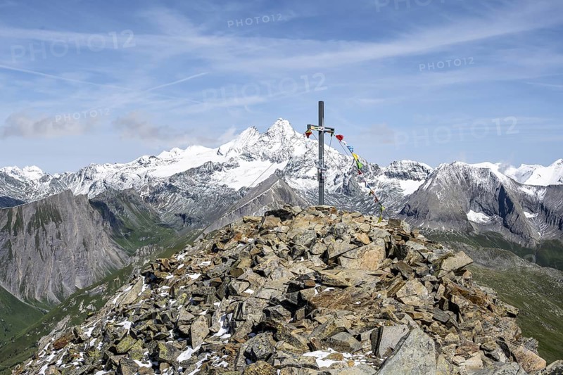 Summit cross of the summit Böses Weibl, behind summit of the Großglockner with snow, Schober group, Hohe Tauern National Park, Carinthia, Austria