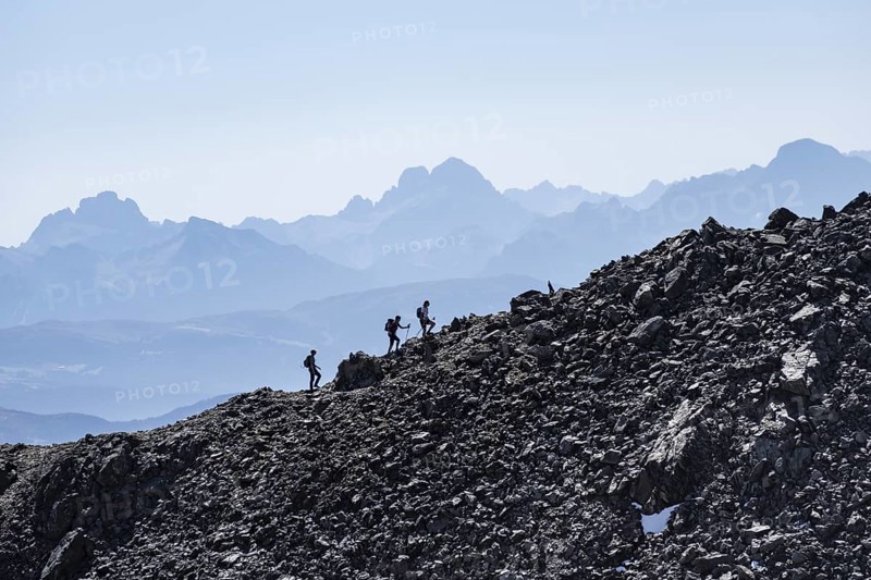 Hikers against the light on a ridge, Stubai Alps, South Tyrol, Italy