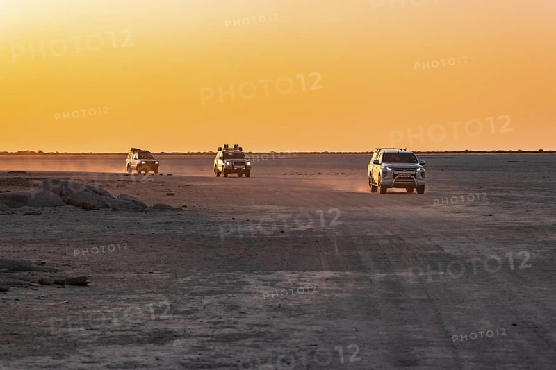 Tourists explore dry landscape by off-road car, Kubu Island (Lekubu), Sowa Pan, Makgadikgadi salt pans, Botswana