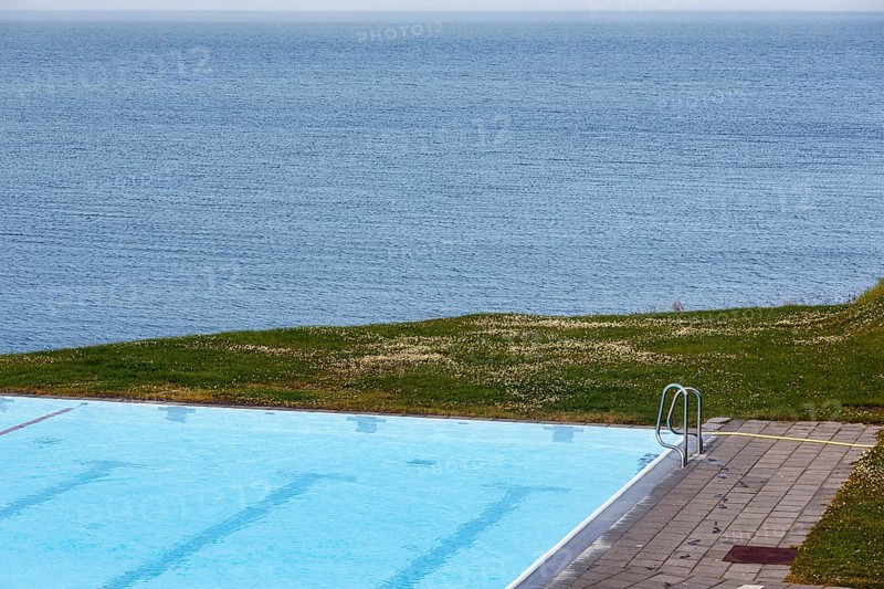 View from above of swimming pool by the sea, thermal bath, heated outdoor pool in Hofsos at the fjord Skagafjördur, Lake Greenland, Hofsos, Tröllaskagi peninsula, Nordurland vestra, North Iceland, Iceland