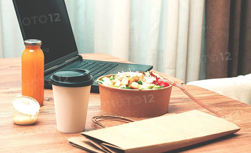 Work at home on a laptop, there is food on the table, salad, coffee and juice, delivery, there are no people