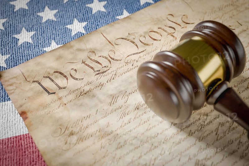 United states constitution, gavel and american flag resting on table