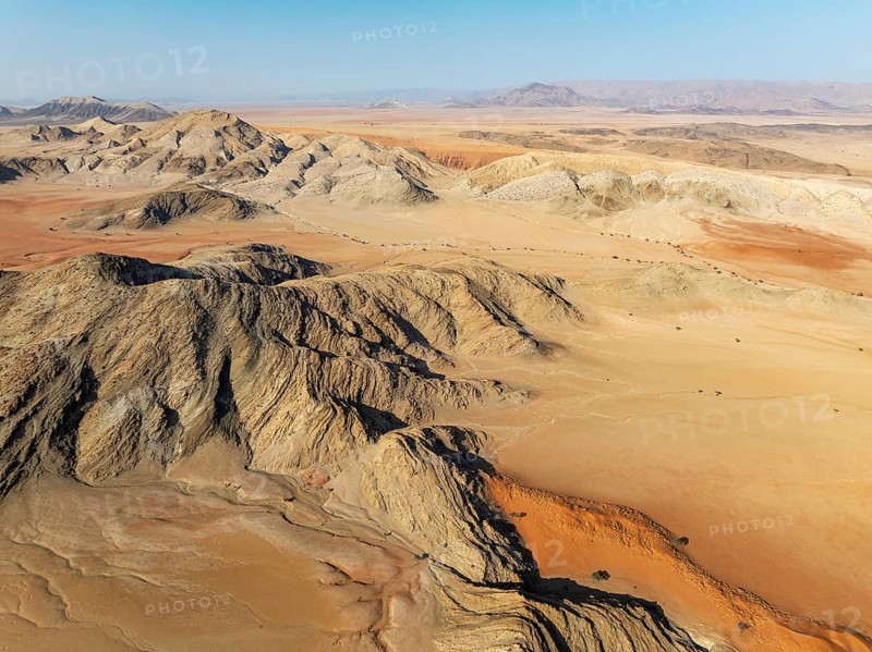Arid plains, sand dunes and bare mountain ridges in the Tsondab Valley in the Namib Desert. Aerial view. Drone shot. Namibia
