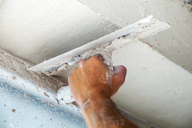 Plasterer smoothing and levelling interior walls