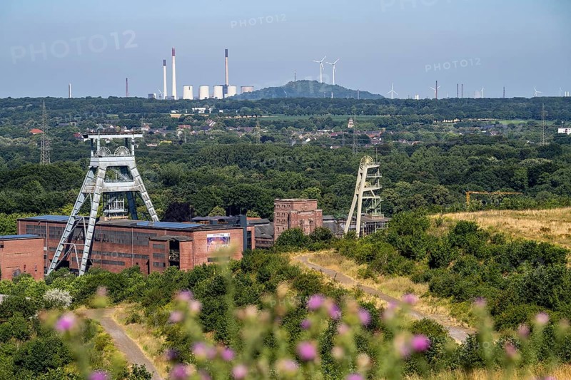 The double headframe of the disused Ewald mine, shaft 7, on the right headframe shaft 2, in Herten, in the background the UNIPER coal-fired power station Scholven, Gelsenkirchen, Scholten spoil tip with 2 wind turbines, North Rhine-Westphalia, Germany