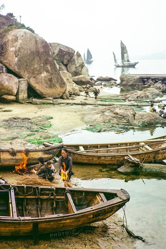 Cleaning the hull of a boat with flames from a small fire in a process known as breaming, Castle Peak, New Territories, Hong Kong, Asia, 1964