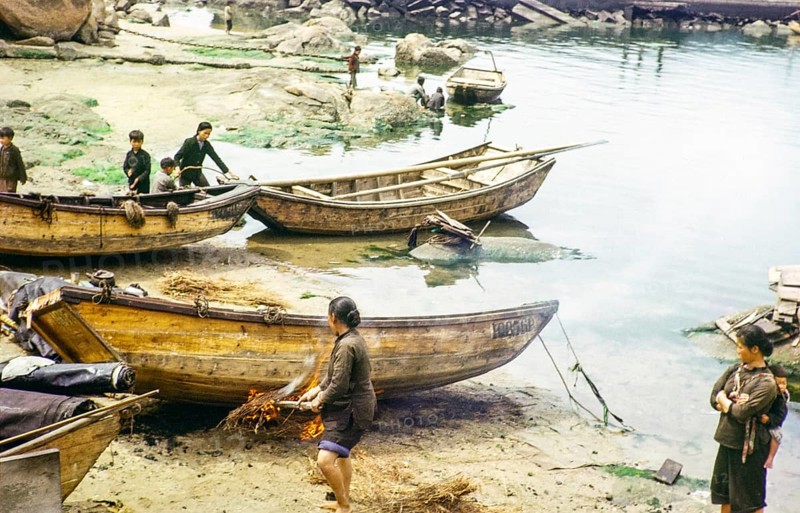 Cleaning the hull of a boat with flames from a small fire in a process known as breaming, Castle Peak, New Territories, Hong Kong, Asia, 1964