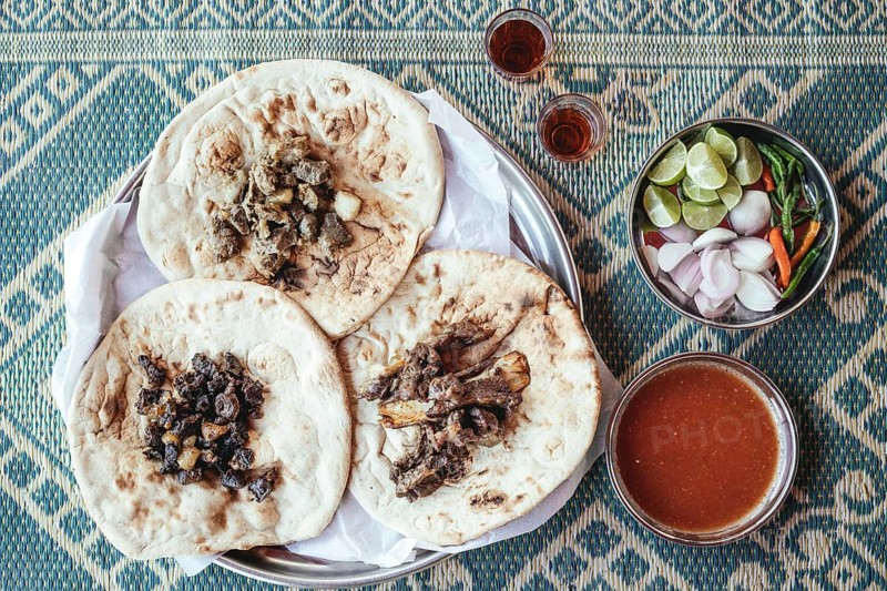 Traditional camel restaurant in Salalah, three kinds of camel meat (dry braised, boiled and grilled/baked), traditionally served with bread and chutney, Dhofar, Oman