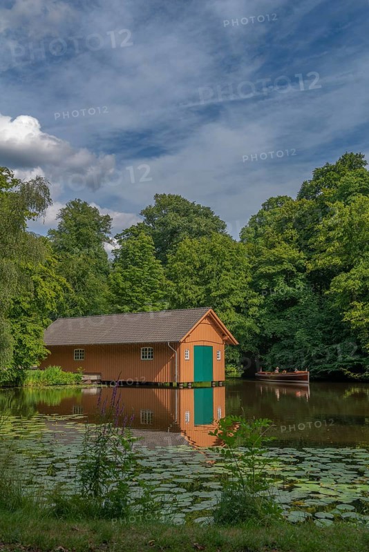 Boathouse at the Meiereisee in the Bürgerpark dating from 1866, passenger ship Marie, round trip, tourism, landscape park with rivers and lakes, garden monument, attraction, recreation, groups of trees, water reflection, water lilies, city state of Bremen, Germany
