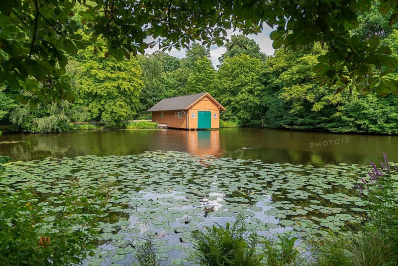 Boathouse at Meiereisee in Bürgerpark from 1866, landscape park with rivers and lakes, garden monument, attraction, recreation, groups of trees, nature, water reflection, water lilies, city state of Bremen, Germany