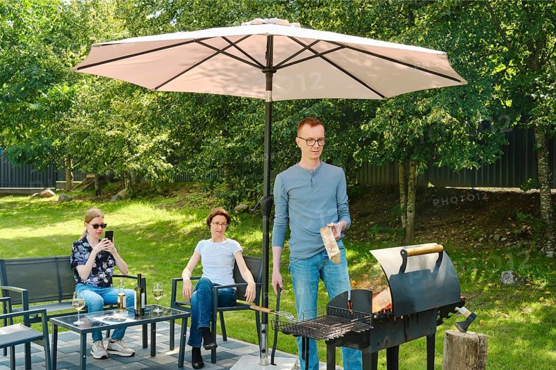 A family gathered in the backyard near a weekend barbecue