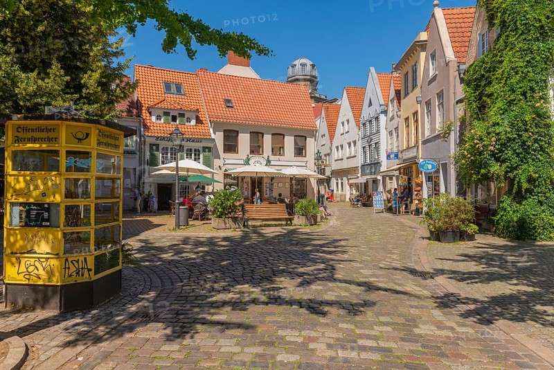 Renovated Schnoor district with small shops, square with historic public telephone, telephone box, skipper's house, flower pots, green walls, people, galleries, restaurants, cafés and residential buildings, Gängeviertel in the old town, former fishermen's and skippers' settlement, narrow alleys, pedestrian zone, numerous listed buildings, classicist, historic, baroque and renaissance architecture, tourist attraction, destination, pleasure, Hanseatic city of Bremen, Germany