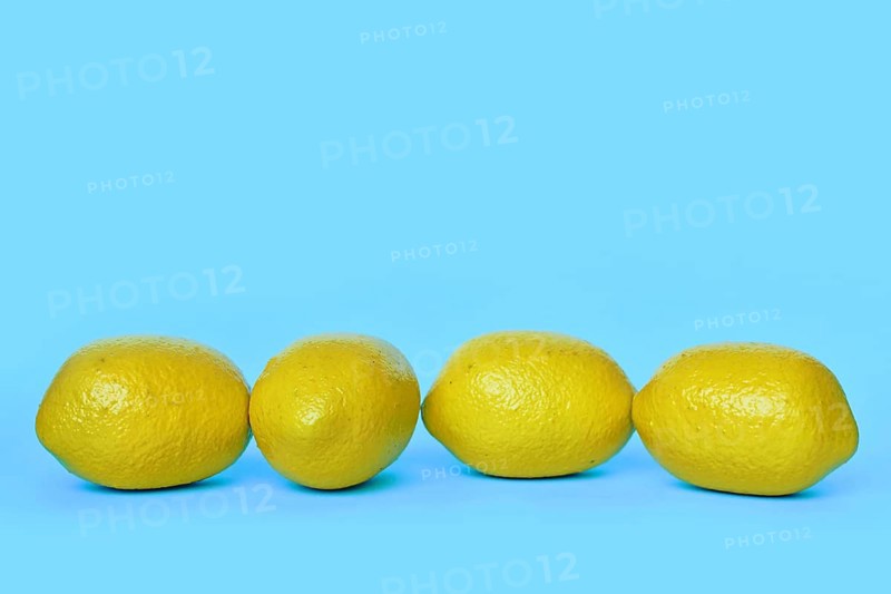 Four lemon fruits on blue background with copy space