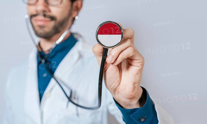 Doctor holding stethoscope with Monaco flag. Monaco health and care concept, Monaco flag on stethoscope