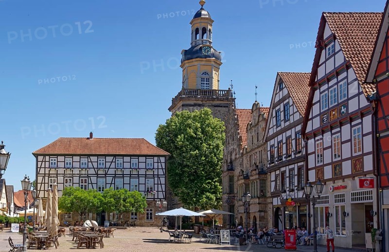 Half-timbered houses on the market square in the historic old town of Rinteln, with the steeple of St Nicholas Church in the background. Lower Saxony, Germany