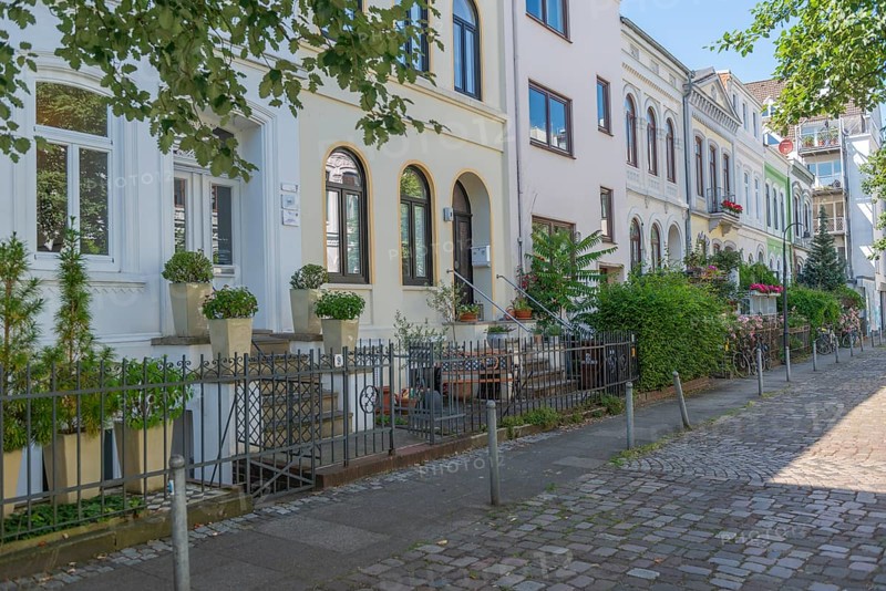 Residential street in the Ostertor neighbourhood a popular residential area, eastern suburb, Wilhelminian style buildings, traffic-calmed, whitewashed facades, cobblestones, stairs to the entrance, plants, trees, sunshine, Bremen, Germany