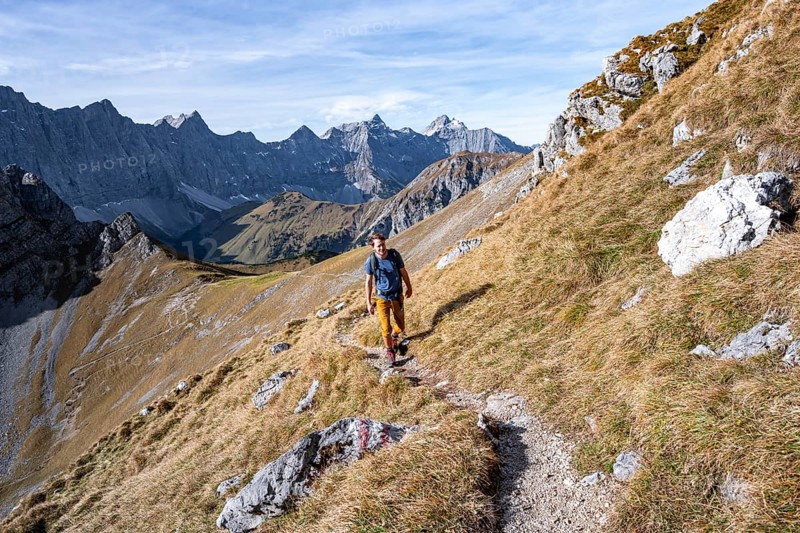 Mountaineers on a hiking trail at the Gamsjoch, picturesque mountain landscape in autumn, view of the rocky mountain ridge of the Hinterautal-Vomper chain, RiÃŸtal in the Eng, Karwendel, Tyrol, Austria
