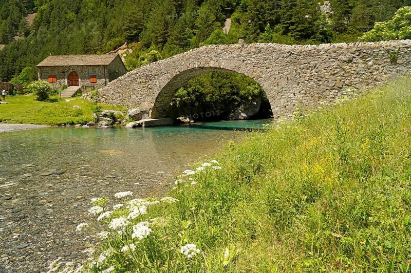 The Romanesque bridge Puente RomÃ¡nico de San NicolÃ¡s de Bujaruelo over the River Ara in the Bujaruelo Valley or Valle de Bujaruelo and the church Iglesia de San NicolÃ¡s de Bujaruelo near Torla-Ordesa, Spain
