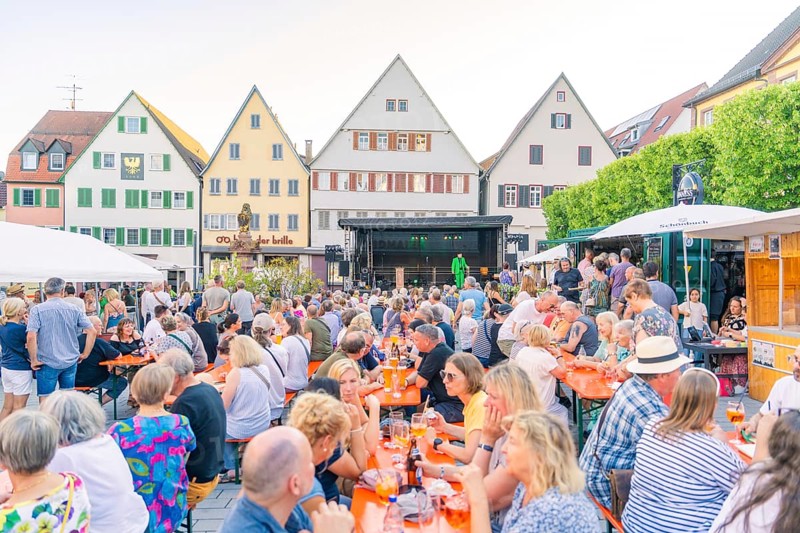 People gather on a market square to enjoy the summer evening, 950 years Weil der Stadt ceremony, Böblingen district, Germany