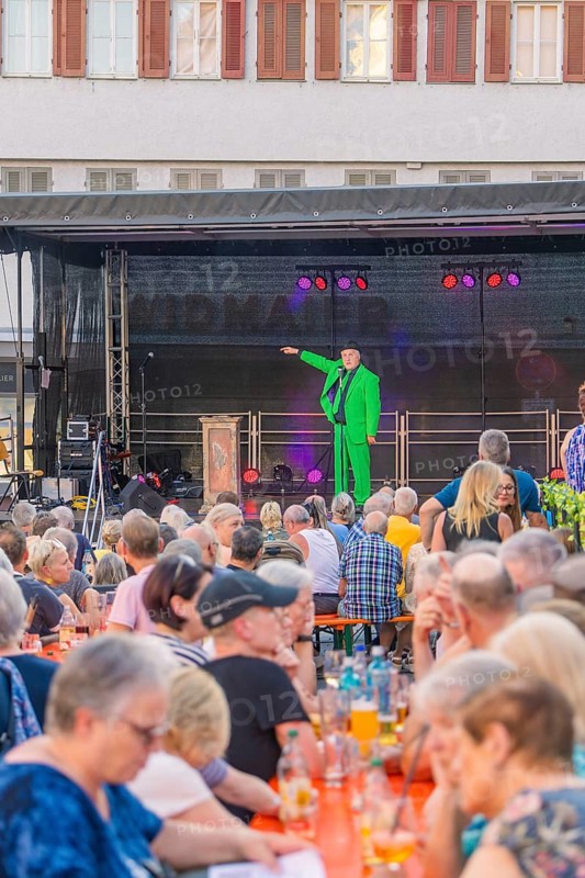 A man in a green suit stands on a stage and speaks to a large crowd, 950 years Weil der Stadt ceremony, Böblingen district, Germany