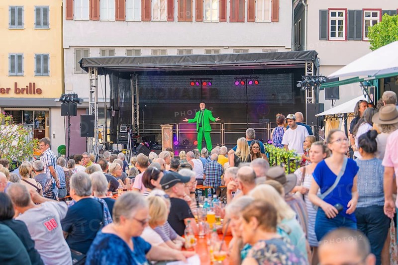 A man on stage entertains a large audience at an outdoor event, 950 years Weil der Stadt ceremony, Böblingen district, Germany