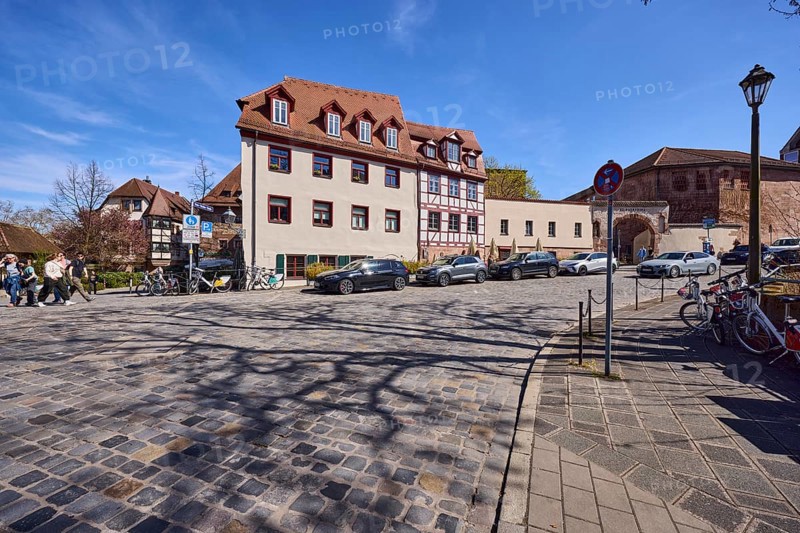Street, cobblestone pavement, historic buildings, half-timbered house, lantern, parking lane with vehicles, blue sky, cirrostratus clouds, intersection Peter-Vischer-StraÃŸe with wasp nest, Nuremberg, Middle Franconia, independent city, Bavaria, Germany