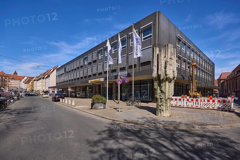 Commerzbank, modern architecture, stone fountain, fenced-off construction site, flags, flagpoles, blue sky, cirrostratus clouds, intersection Spitalgasse with Hans-Sachs-Platz, Nuremberg, Middle Franconia, independent city, Bavaria, Germany