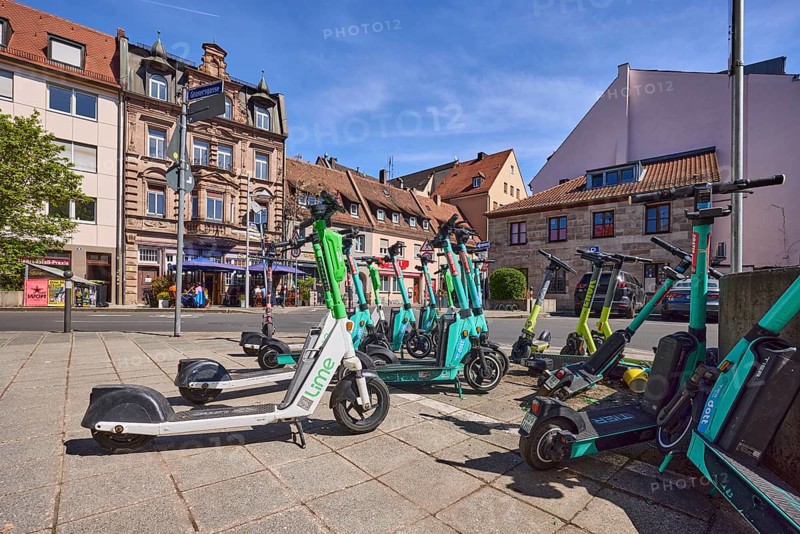 E-scooter in the city, problem, traffic problem, general architecture, pavement, pavement slabs, tree, frog perspective, blue sky, cirrostratus clouds, intersection Grasersgasse with Dr.-Peter-Schönlein-Platz and Klaragasse, Nuremberg, Middle Franconia, independent city, Bavaria, Germany
