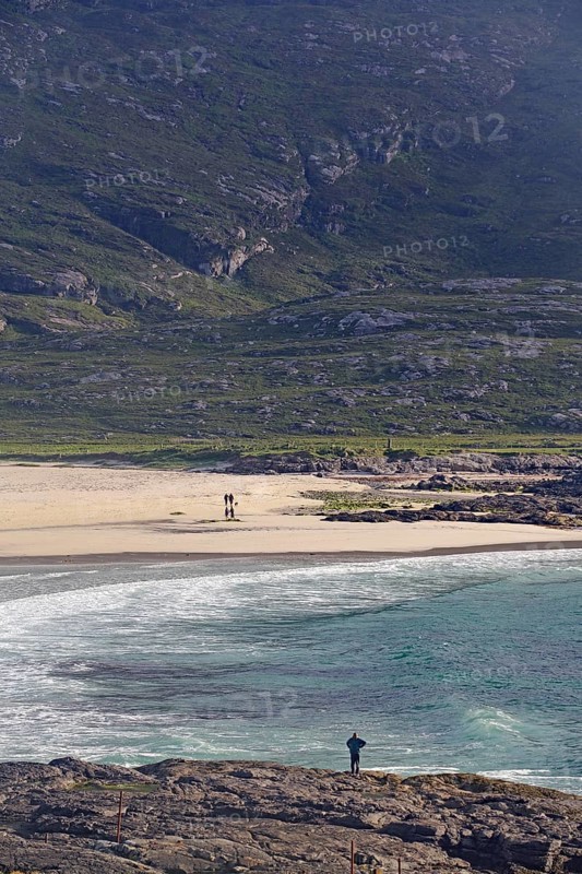 A picturesque beach with clear waters, surrounded by rocky cliffs and rolling hills, Outer Hebrides, Isle of Barra, Scotland, United Kingdom