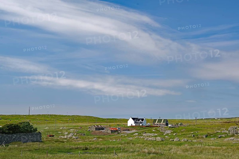 Rural area with a remote farmhouse under a wide blue sky, Outer Hebrides, South Uist, Scotland, United Kingdom