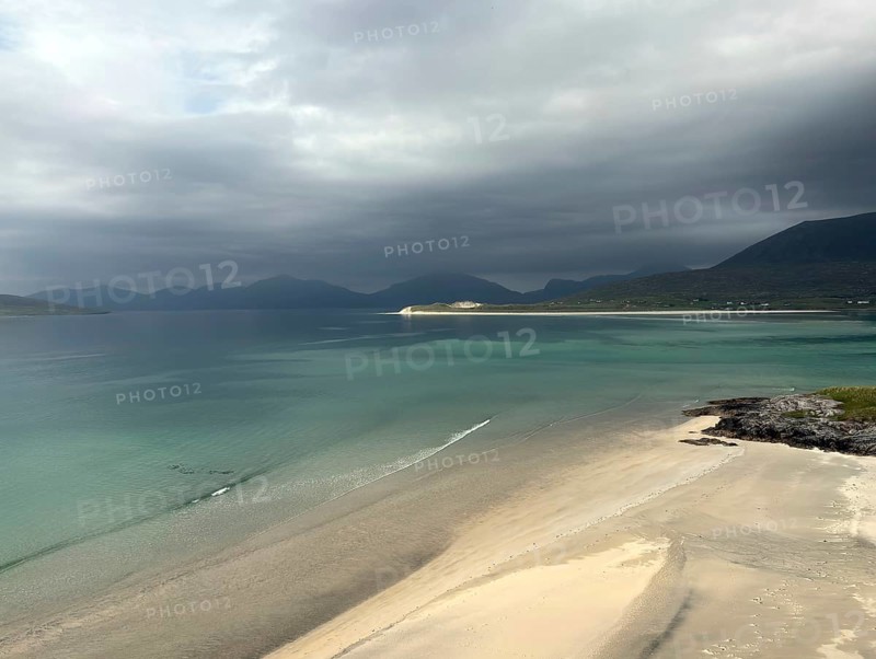 Stormy coastal view with grey sky and calm sea to the shore of a wide bay, Outer Hebrides, Isle of Harris, Scotland, United Kingdom