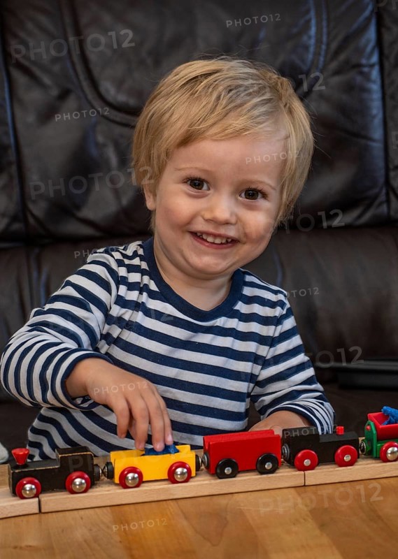 Blond boy, 2 years old, playing with toy train in Ystad, SkÃ¥ne County, Sweden, Scandinavia