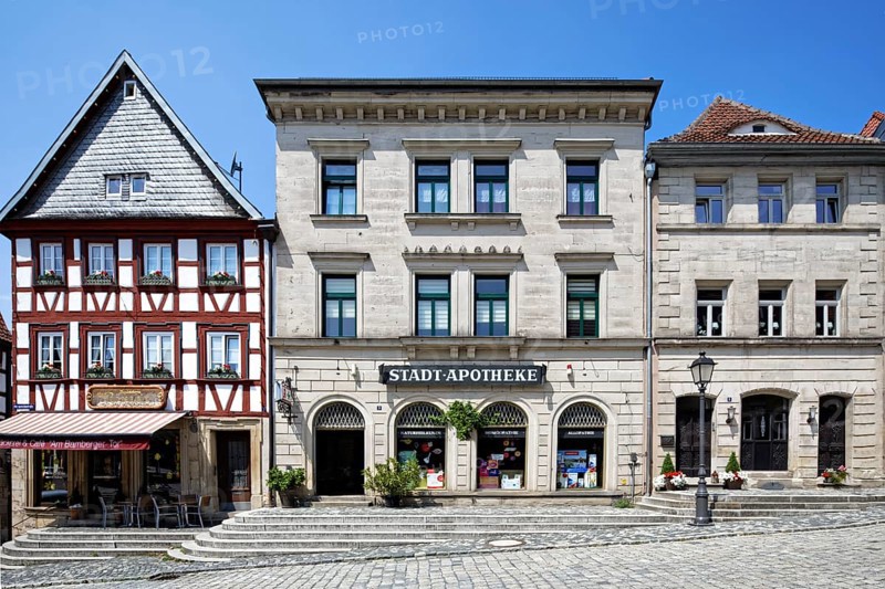 Beautiful row of houses, from left, residential building, half-timbered building, commercial building, three-storey corner building with gabled roof, two half-timbered upper storeys, 1746, gable slated, town pharmacy 1846, three-storey sandstone ashlar building with hipped roof, classicism, three-storey sandstone ashlar building with hipped roof, mid-19th century, Birthplace of Bishop Josef Stangl, AmtsgerichtsstraÃŸe, cobbled, Upper Town, Old Town, Kronach, Upper Franconia, Franconia, Bavaria, Germany