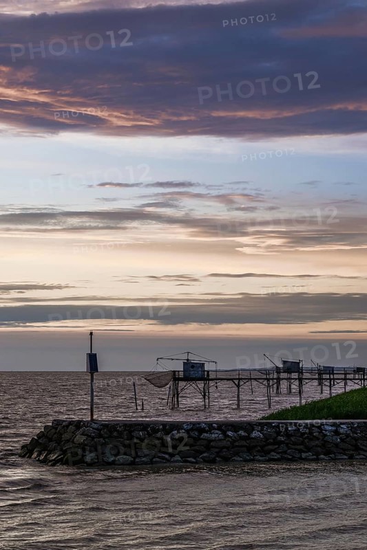 Sunset over Fishing huts over Gironde Estuary, Braud-et-Saint-Louis, France