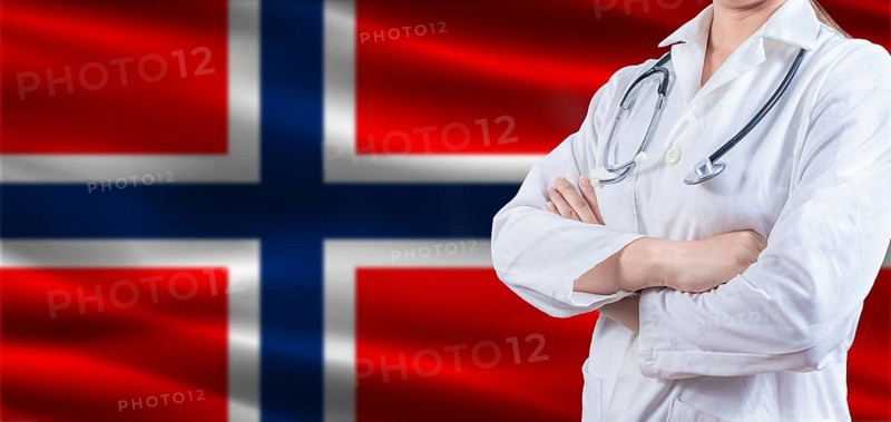 Doctor with crossed arms on Norway flag. Norway health and care concept. Female doctor on Norway flag