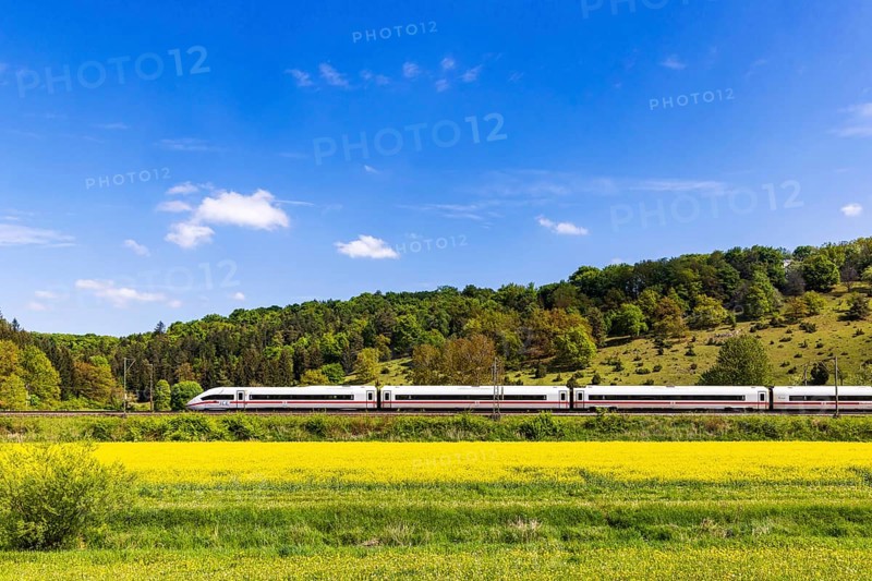 InterCityExpress ICE en route on the Swabian Alb near Lonsee. Landscape on the railway's Filstalline line in spring with rape fields in bloom. Lonsee, Baden-WÃ¼rttemberg, Germany