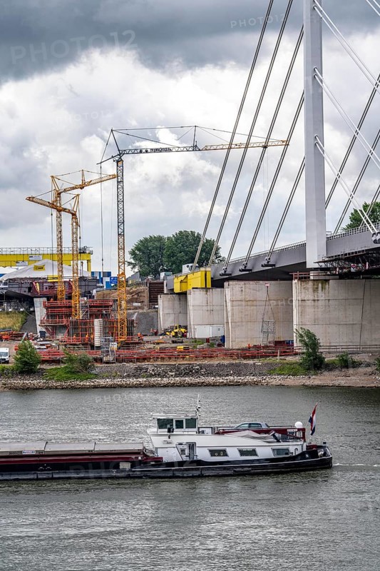 Rhine bridge Duisburg-Neuenkamp, the A40 motorway, start of construction of the second bridge, bridge piers and the first bridge segment are erected on the Neuenkamp side of the Rhine, cargo ship on the Rhine, North Rhine-Westphalia, Germany