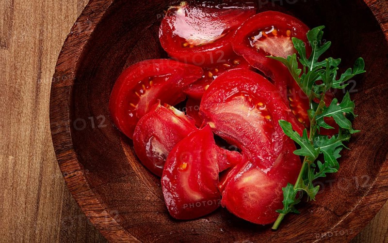 Sliced tomato, on a wooden plate, tomato salad, food background, no people