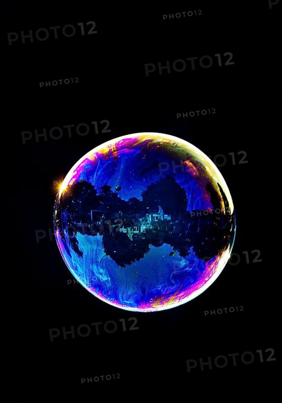 A shimmering and floating soap bubble in the colours of the rainbow against a black background, Recklinghausen, Germany
