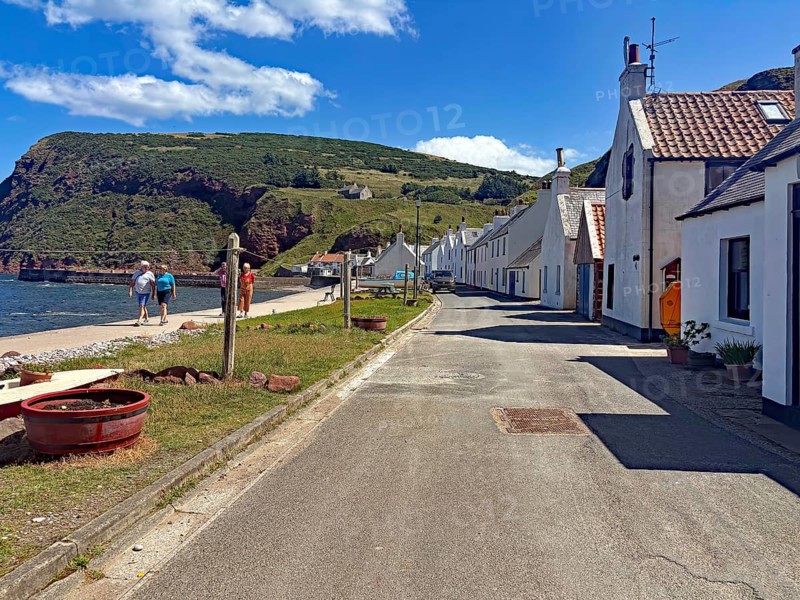 Picturesque coastal road along a small village with houses and a rocky coastline in serene weather, Local Hero, burt Lancaster, Pennan, film location, Aberdeenshire, Scotland, United Kingdom