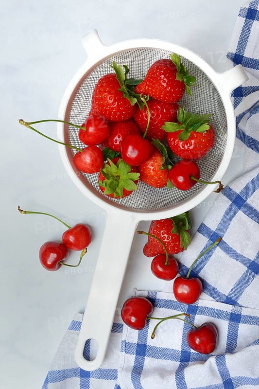 Cherries and strawberries in a colander, fruit