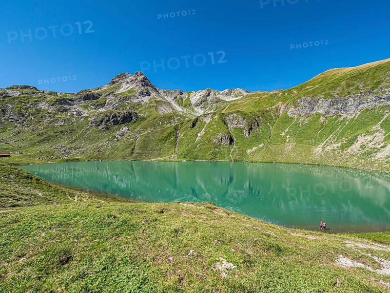 Hiker at lake Engeratsgundsee, mountain range between Oberstdorf and Bad Hindelang, Allgaeu, Bavaria, Germany